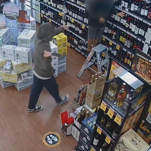 WATCH: Moment masked thief pulls knife on Gold Coast bottle shop worker