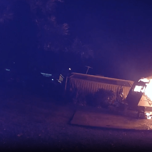 WATCH: Quick-thinking cop stops Gold Coast caravan fire from spreading